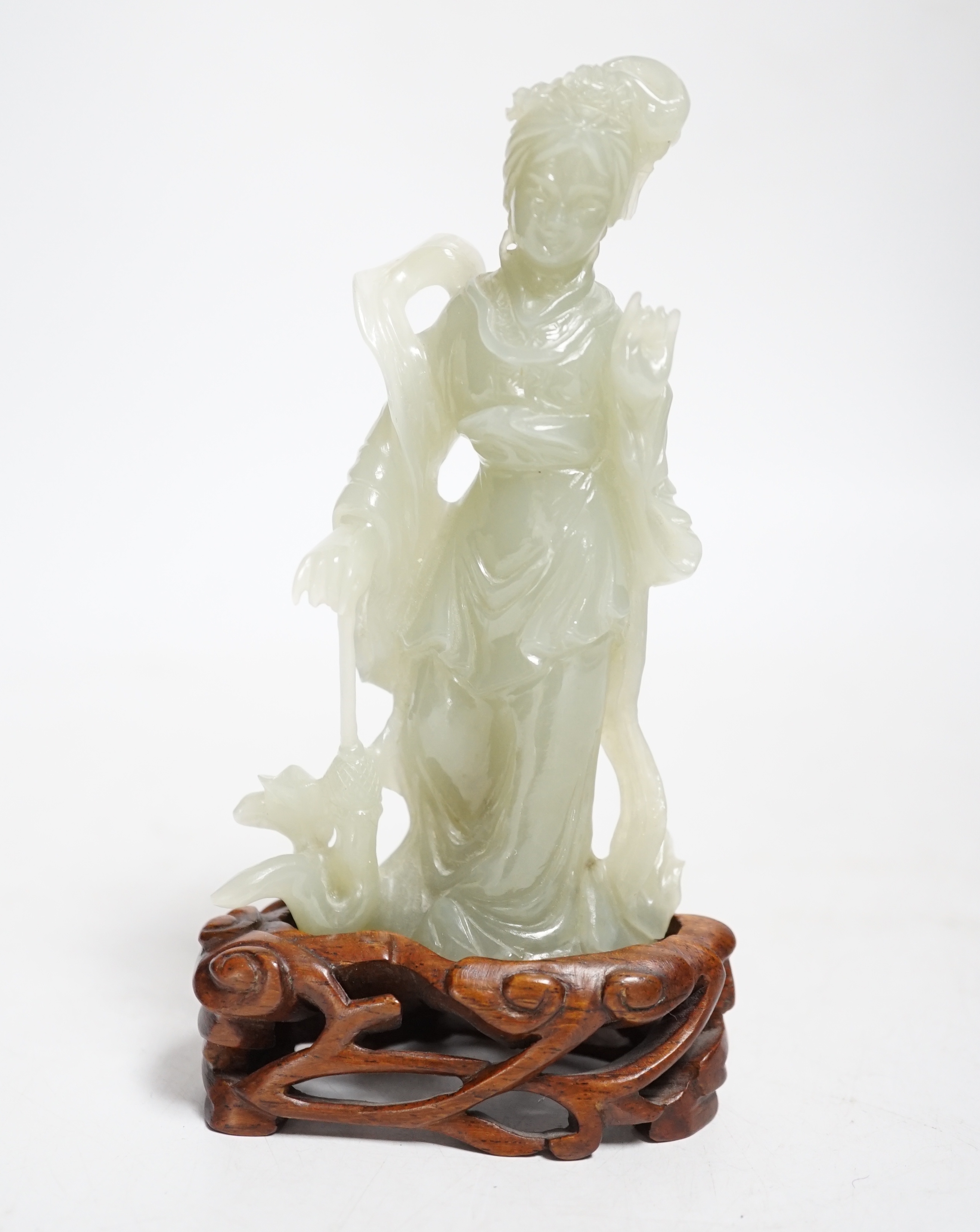 A Chinese celadon jade figure of a lady, on wood stand, 13cms high.